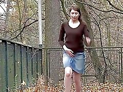 Håriga flicka lyfter sin skirt och pissar utomhus