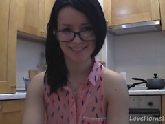 adolescente espléndida con gafas en el chat en la cocina