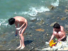 Meninas nuas do espião na costa da praia